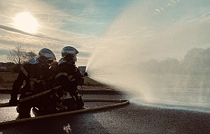 Pompiers avec une lance